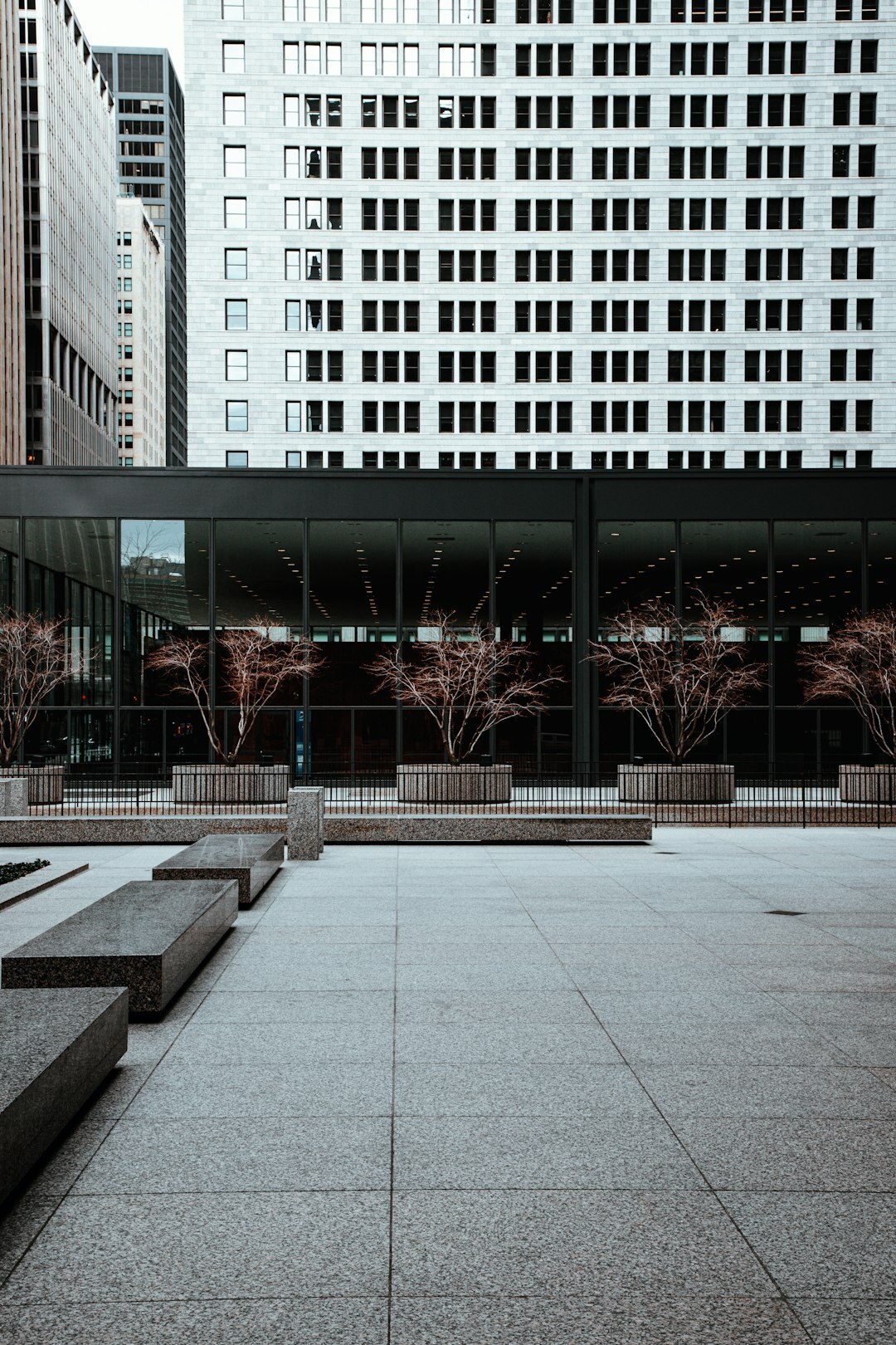 Empty city plaza with worn benches under overcast sky