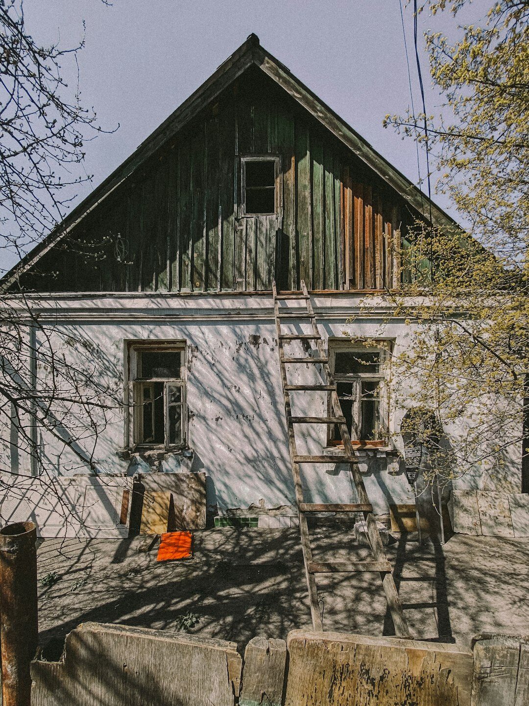elderly man in front of old house